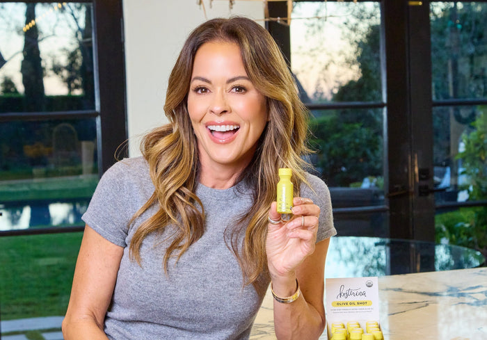 Woman holding a bottle of a product in a home setting